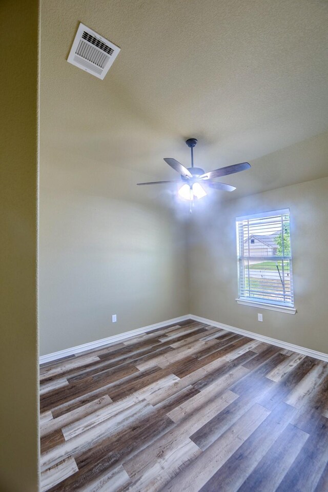 spare room with hardwood / wood-style floors, ceiling fan, and a textured ceiling