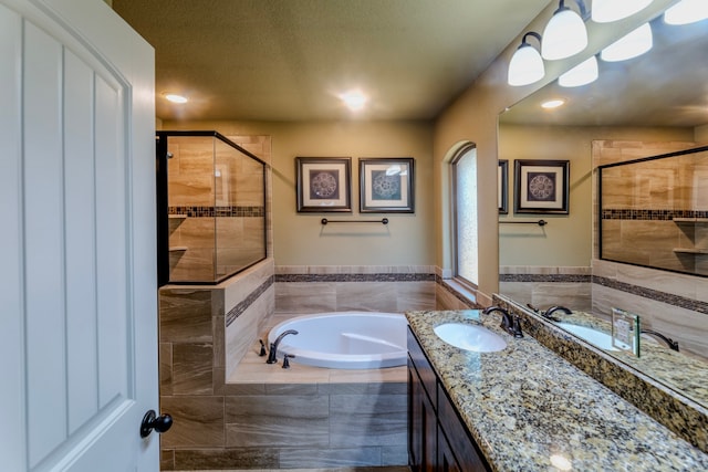 bathroom featuring shower with separate bathtub, a textured ceiling, and vanity