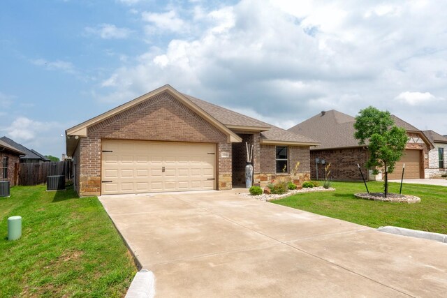 view of front facade featuring a garage, cooling unit, and a front lawn