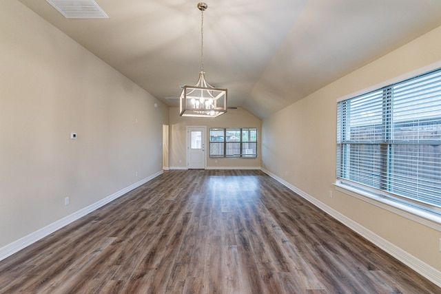 interior space featuring dark wood-type flooring, lofted ceiling, and a notable chandelier