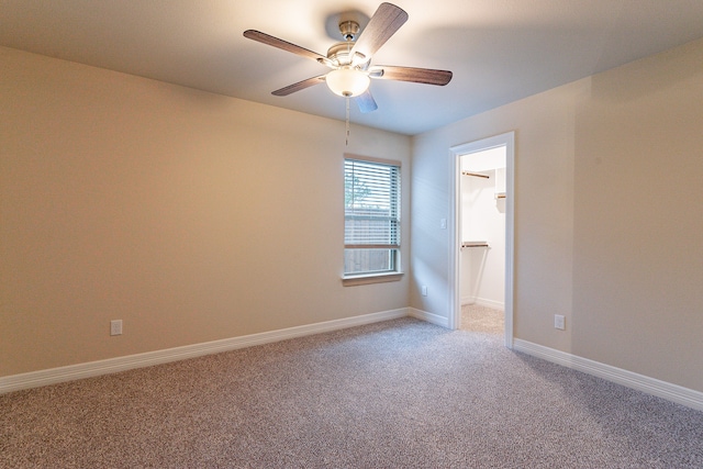 spare room with ceiling fan and carpet