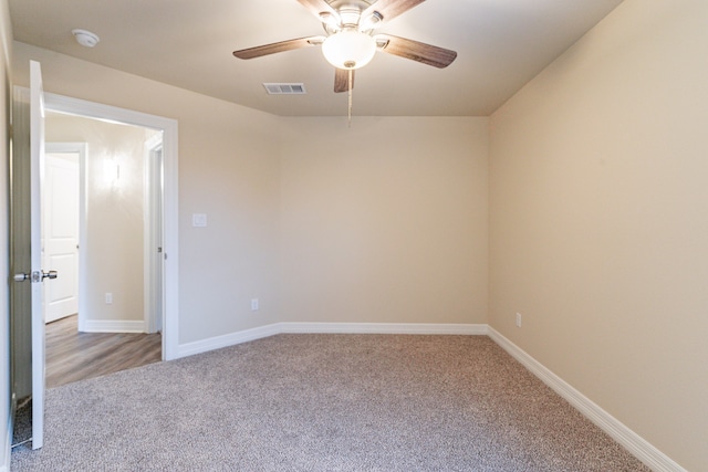 carpeted spare room with ceiling fan