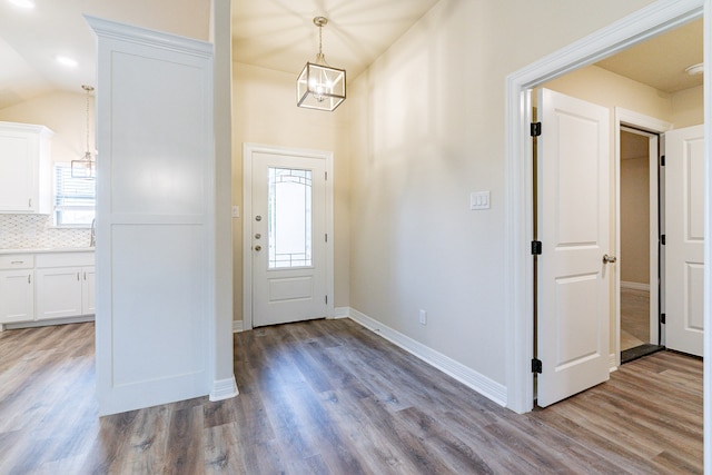 entrance foyer featuring light wood-type flooring, a wealth of natural light, and vaulted ceiling