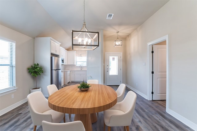 dining room with dark hardwood / wood-style flooring and a healthy amount of sunlight