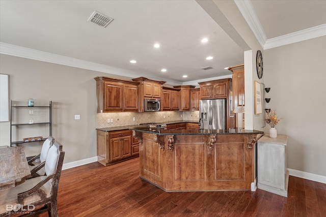 kitchen featuring stainless steel appliances, ornamental molding, dark stone counters, a kitchen bar, and dark hardwood / wood-style floors