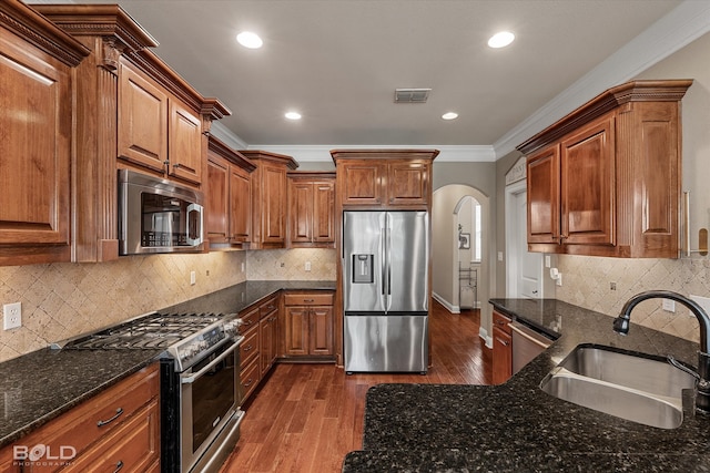 kitchen with stainless steel appliances, dark wood-type flooring, sink, and backsplash