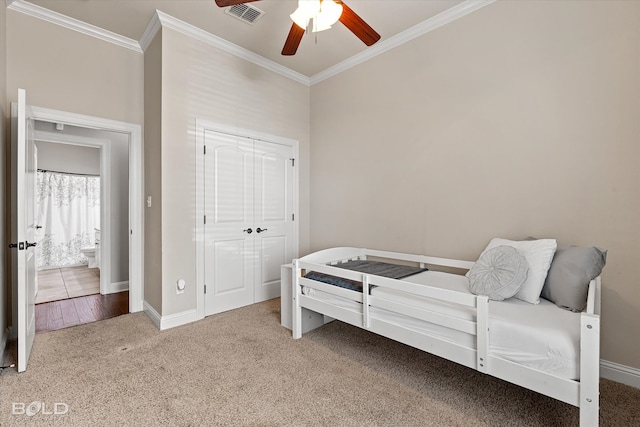 carpeted bedroom featuring a closet, ceiling fan, and crown molding