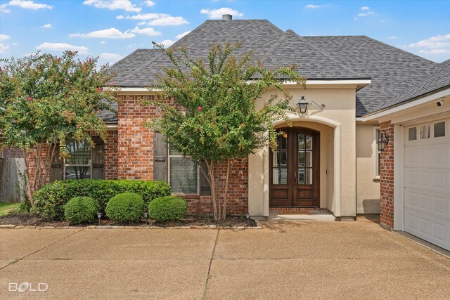 entrance to property featuring a garage and french doors