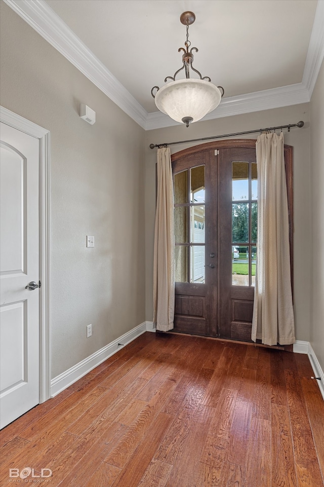 interior space with wood-type flooring, ornamental molding, and french doors