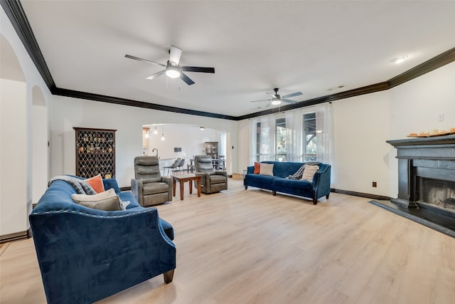 living room featuring light hardwood / wood-style floors, crown molding, and ceiling fan