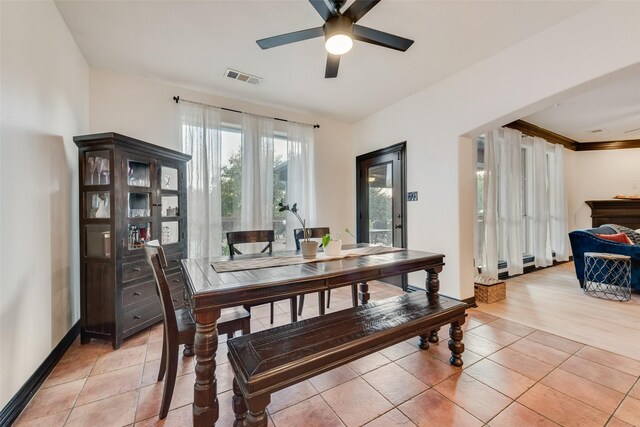 tiled dining room with a baseboard heating unit and ceiling fan