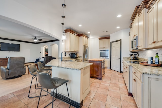 kitchen featuring decorative light fixtures, a breakfast bar, kitchen peninsula, sink, and appliances with stainless steel finishes