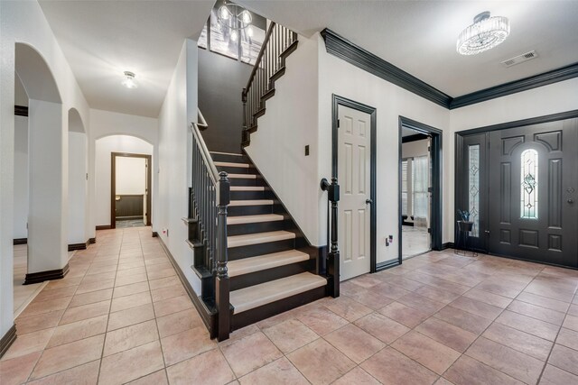 entryway featuring light tile patterned floors and ornamental molding