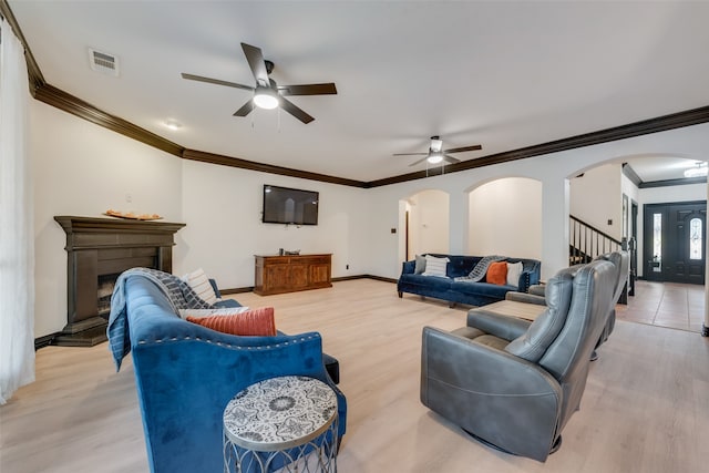 living room with ceiling fan, light wood-type flooring, and ornamental molding