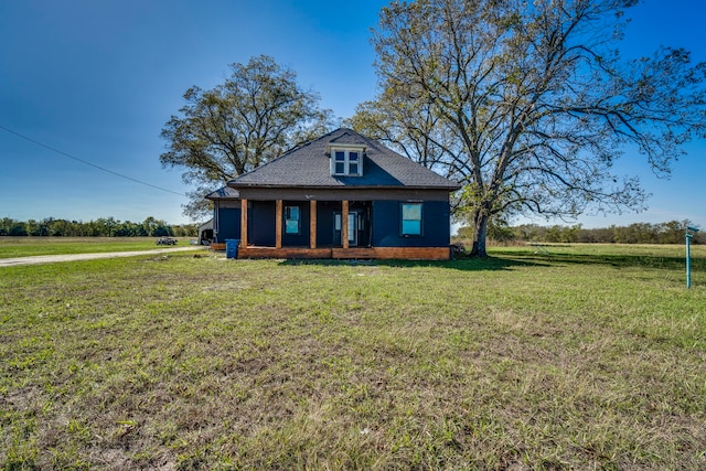 view of front of home with a front lawn and a rural view