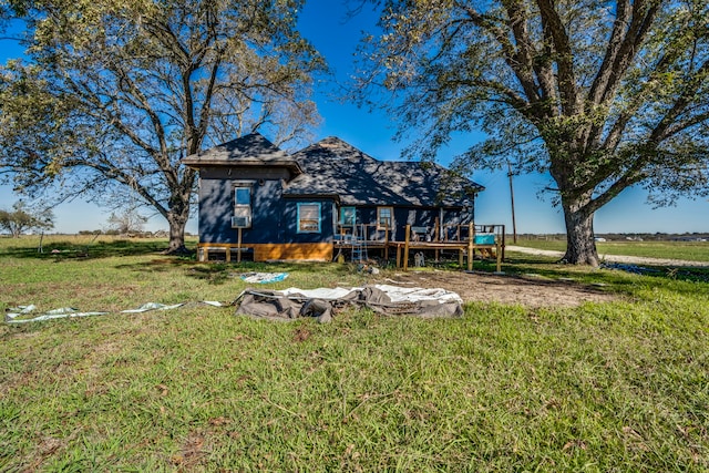 rear view of house featuring a wooden deck and a lawn