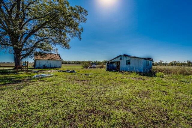 view of yard with an outbuilding and a rural view