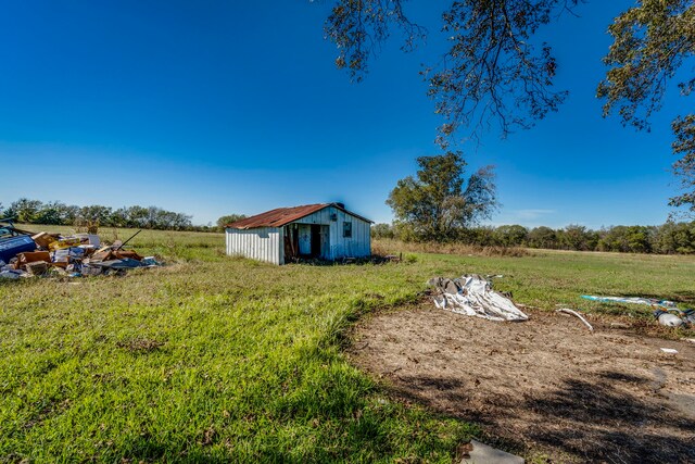 view of yard featuring a rural view and a shed