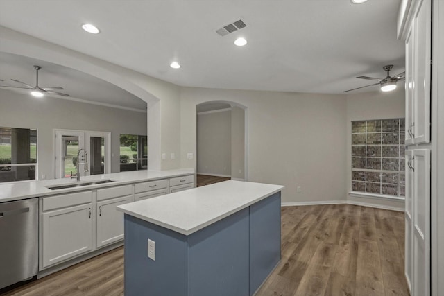 kitchen featuring sink, dishwasher, white cabinets, hardwood / wood-style floors, and a kitchen island