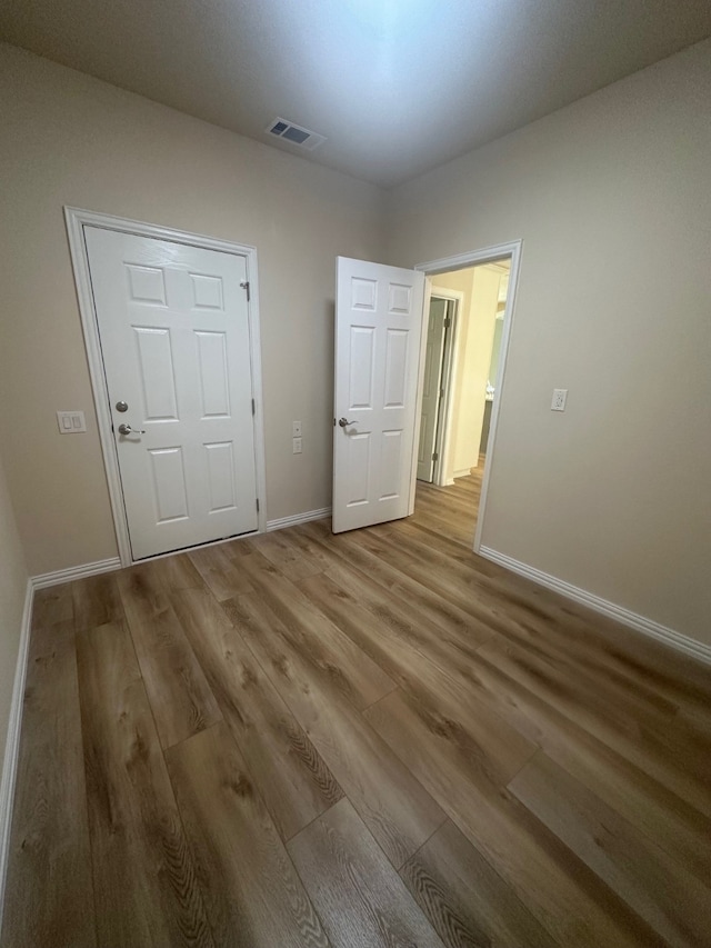 unfurnished bedroom featuring light hardwood / wood-style floors and a closet