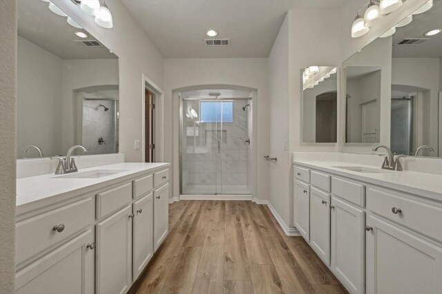 bathroom with vanity, an enclosed shower, and hardwood / wood-style flooring