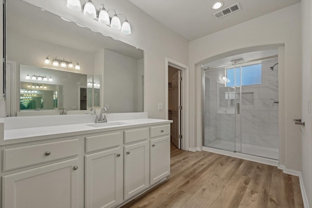 bathroom featuring hardwood / wood-style flooring, vanity, and an enclosed shower