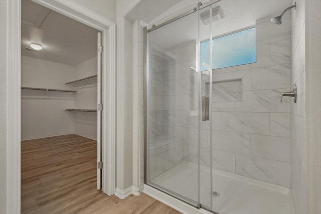 bathroom featuring wood-type flooring and an enclosed shower