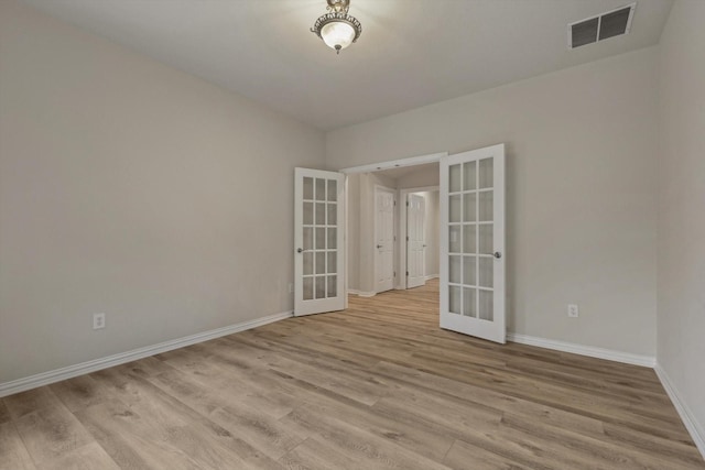 empty room with light hardwood / wood-style flooring and french doors