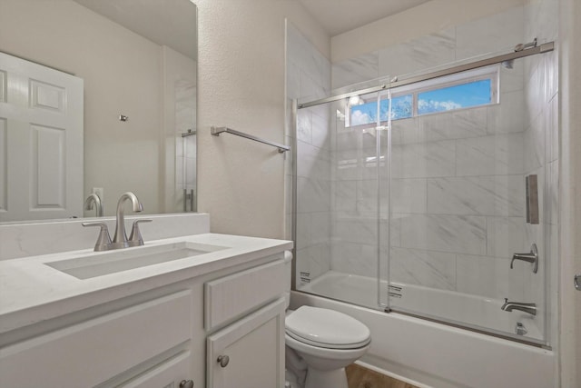 full bathroom featuring vanity, toilet, and bath / shower combo with glass door