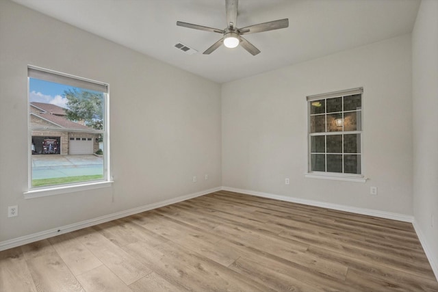 empty room with ceiling fan and light hardwood / wood-style floors