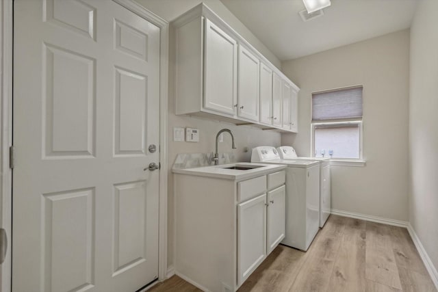 washroom featuring cabinets, independent washer and dryer, light hardwood / wood-style flooring, and sink