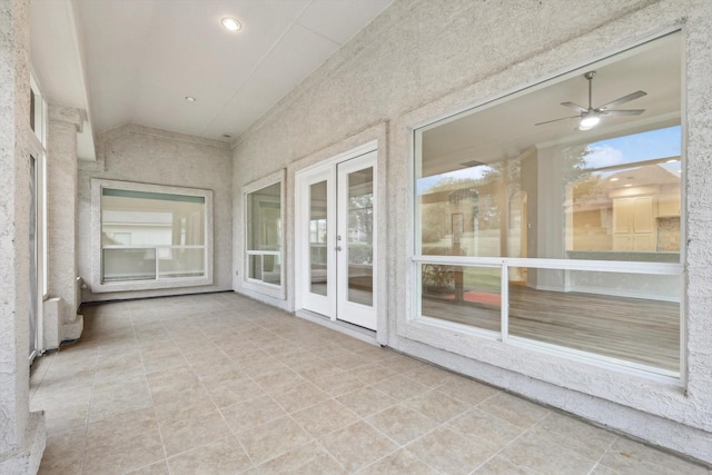 unfurnished sunroom featuring ceiling fan and french doors