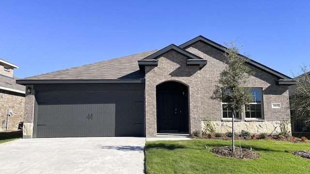 view of front of home featuring a garage and a front lawn