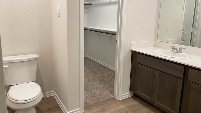 bathroom with hardwood / wood-style flooring, vanity, and toilet