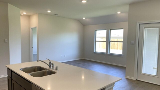 kitchen featuring a center island with sink, vaulted ceiling, sink, and hardwood / wood-style floors