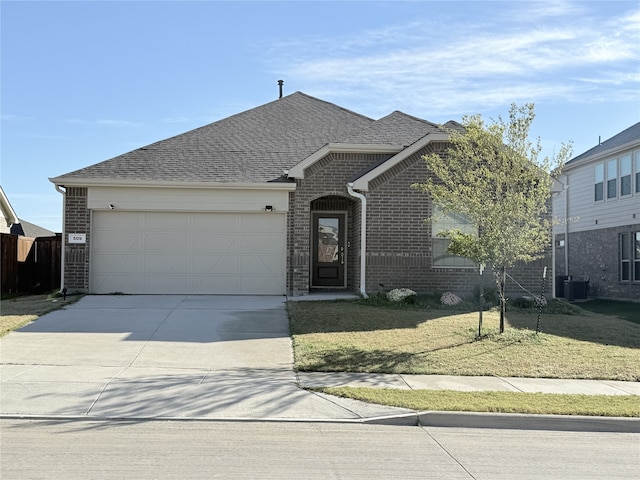 view of front of home with a front lawn, central AC, and a garage