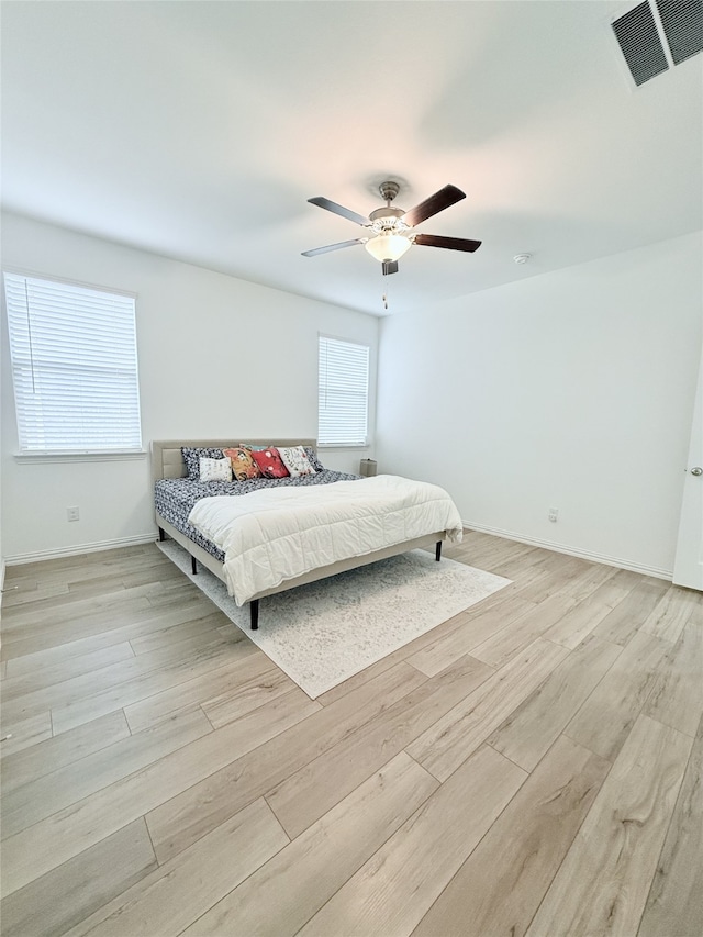 bedroom with light hardwood / wood-style floors, multiple windows, and ceiling fan