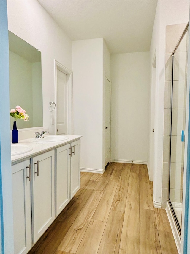 bathroom featuring walk in shower, vanity, and hardwood / wood-style flooring