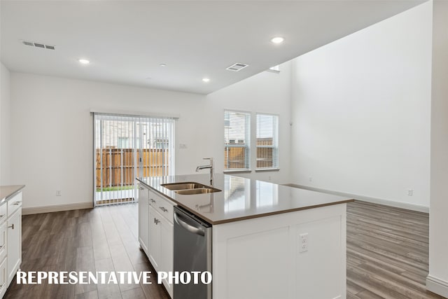 kitchen with sink, a center island with sink, dishwasher, hardwood / wood-style floors, and white cabinetry