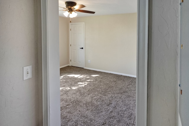 carpeted spare room with ceiling fan