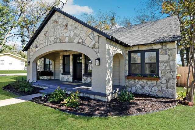 view of front of house with a porch and a front lawn