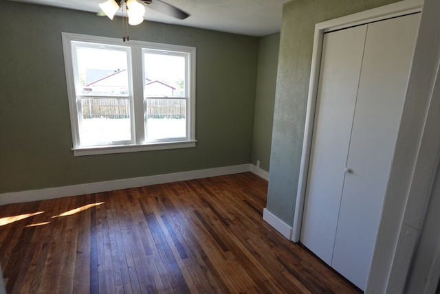 unfurnished bedroom featuring ceiling fan and dark wood-type flooring