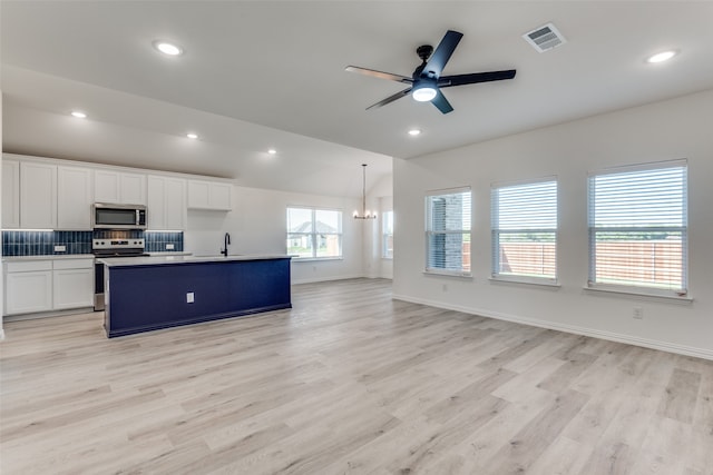 kitchen featuring white cabinetry, pendant lighting, appliances with stainless steel finishes, a kitchen island with sink, and light hardwood / wood-style floors