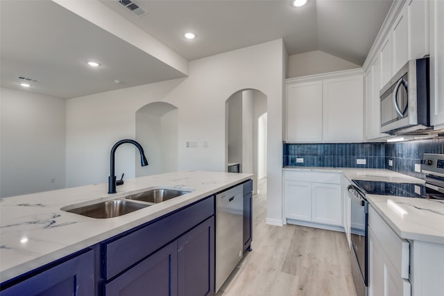 kitchen with white cabinets, appliances with stainless steel finishes, light wood-type flooring, and sink