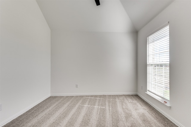 spare room with light carpet and lofted ceiling