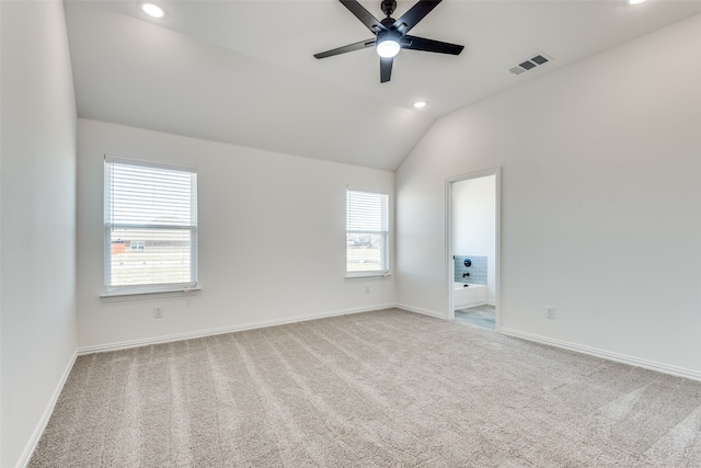 empty room with vaulted ceiling, ceiling fan, and carpet flooring