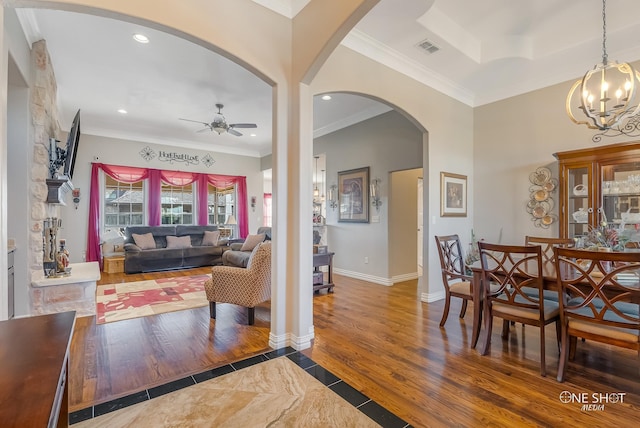 interior space featuring ceiling fan with notable chandelier, crown molding, and a tray ceiling