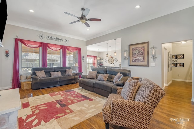 living room featuring hardwood / wood-style floors, plenty of natural light, ornamental molding, and ceiling fan