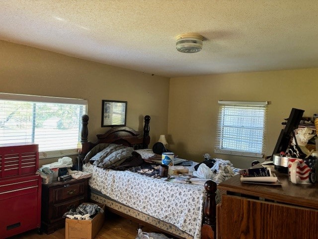 bedroom featuring a textured ceiling and dark hardwood / wood-style floors