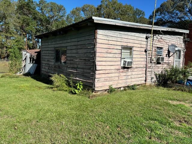 view of outbuilding featuring a lawn and cooling unit